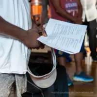photo of a person holding a worship bulletin in church