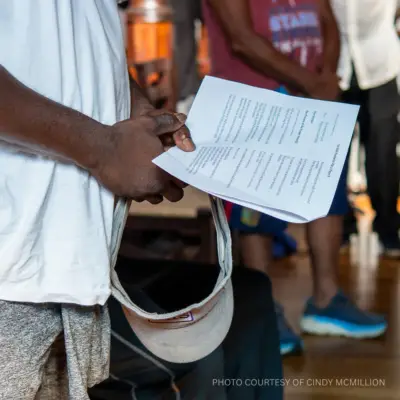 photo of a person holding a worship bulletin in church